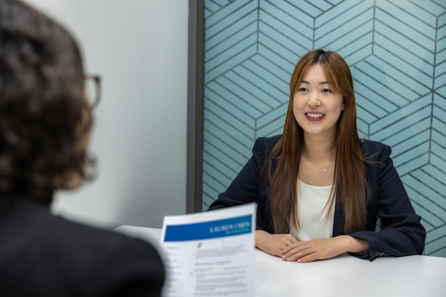 Junge Frau im Gespräch mit Interviewerin während eines Auswahlgesprächs fürs Medizinstudium im Büro.